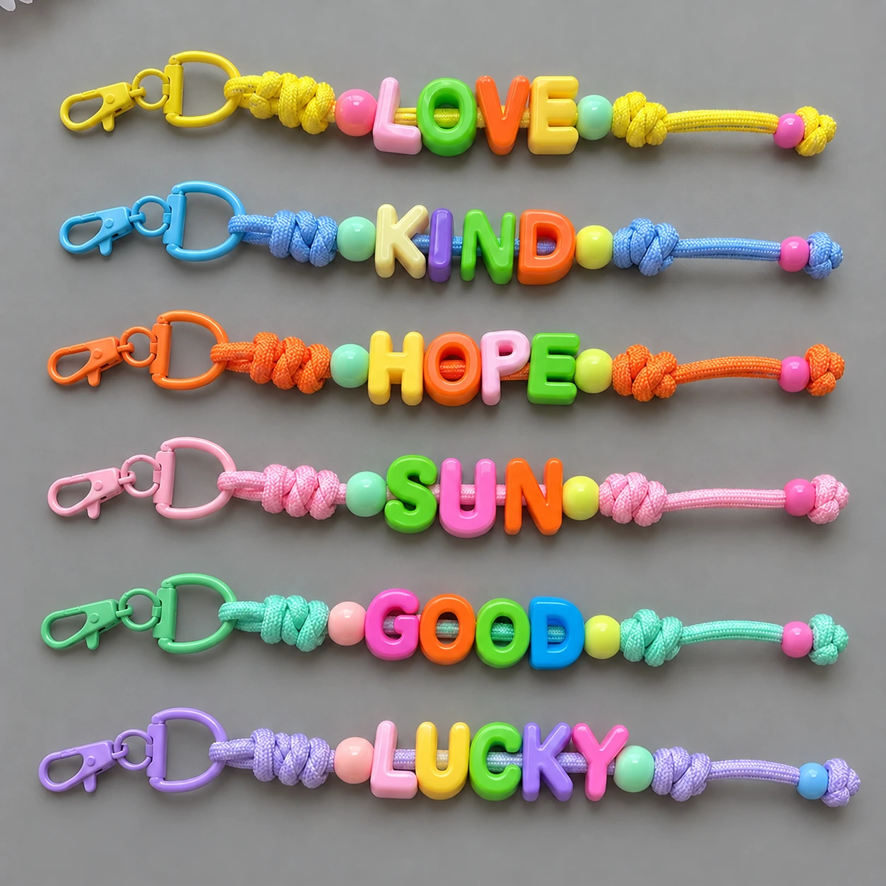 Six chunky bead keychains with multicolored letters, matching cords and semicircle rings